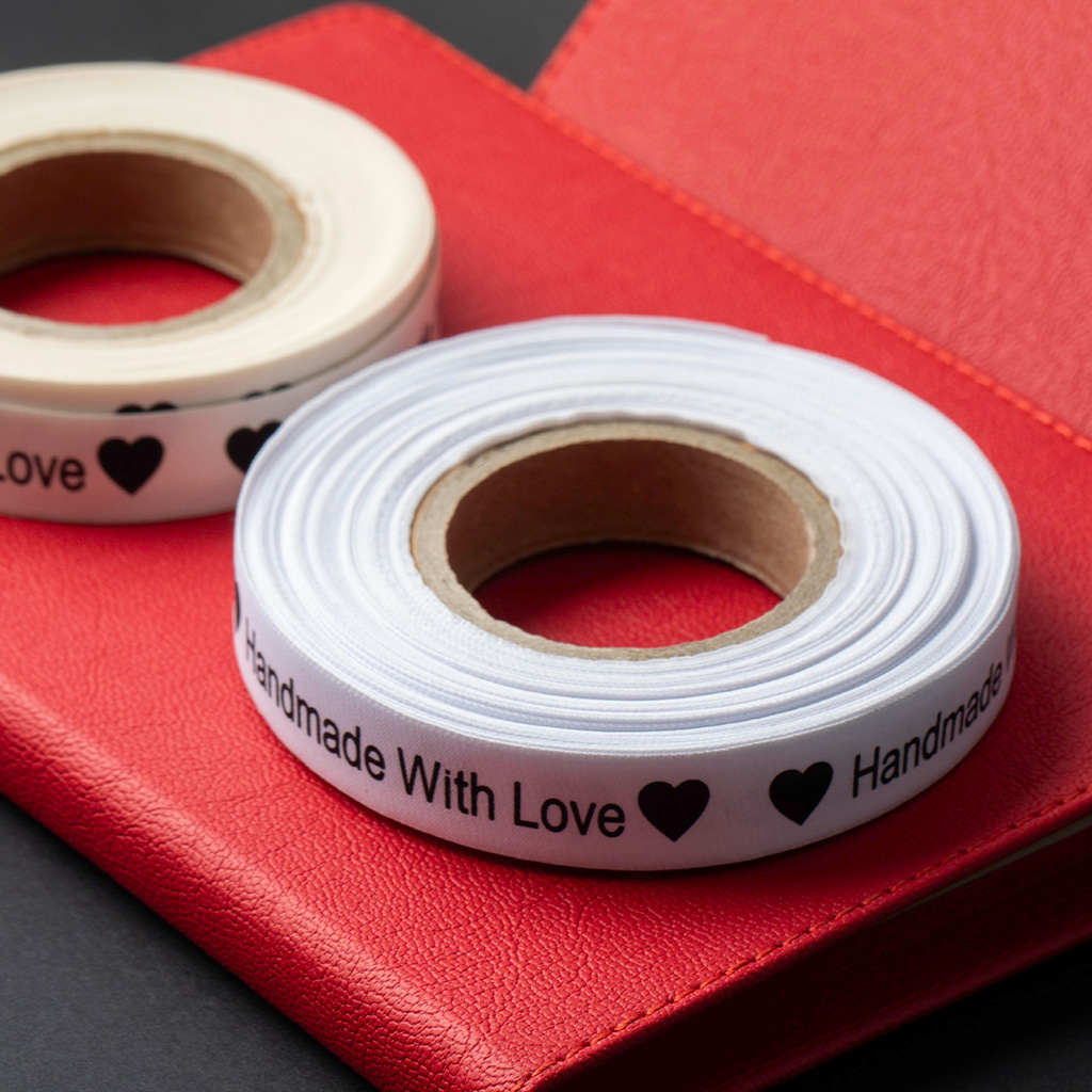 Rollos de cinta de satén blanca con impresión personalizada "Handmade with love".